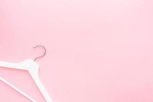 White hangers on pastel pink background photo