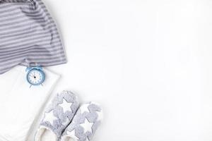 Soft fluffy slippers and blue alarm clock photo