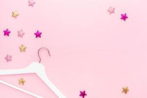 White hangers on pastel pink background photo