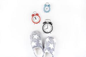 Soft fluffy slippers and alarm clocks photo