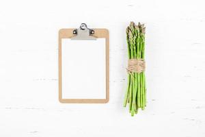 Fresh green asparagus with paper clipboard mockup photo