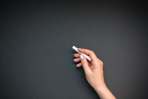 Teacher hand with piece of chalk photo