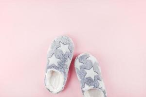 Soft fluffy slippers on pink background photo