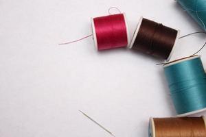 Multi-colored threads and old scissors spread out on a white floor, retro scissors, flat lay, copy space. photo