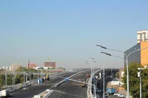 New traffic intersection road construction site on blue sky background. Development of transport infrastructure junction, improvement highway. Overpopulation problem. Erection overpass in the big city photo