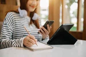 Woman hand working with new modern computer and writing on the notepad strategy diagram as concept photo