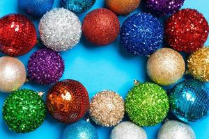 Top view of frame made of decorative balls on colorful background. Christmas toys concept with empty space for your design photo