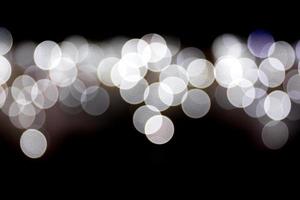 Abstract bokeh of white city lights on black background. defocused and blurred many round light photo