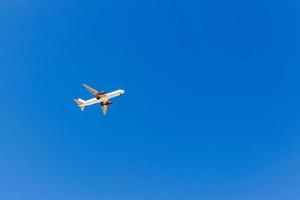 A plane flying in the blue sky without white clouds photo