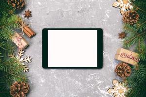 Digital tablet mock up with rustic Christmas gray cement rustic vintage background decorations for app presentation. top view with copy space photo