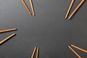 Many bamboo chopsticks on black slate background, textured, top view with opy space photo