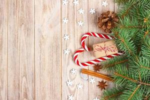 Christmas background with christmas tree branches, pine cones, candy cane sweets, gifts, snowflake and decorations, copy space photo