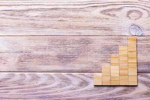 A wooden blocks cube over black wooden textured background with copy space for add word text title. Concept or conceptual Wood block stair or five steps. Cubic photo