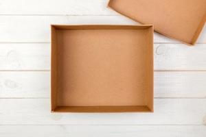 Opened empty cardboard box on wooden background. Top view photo