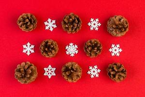 Top view of holiday composition made of pine cones and white snowflakes on colorful background. Winter time and Christmas concept with copy space photo