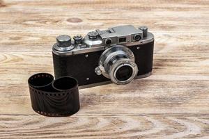 Old photo film rolls with Vintage camera on wooden background