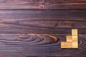 A wooden blocks cube over black wooden textured background with copy space for add word text title. Concept or conceptual Wood block stair or three steps. Cubic photo