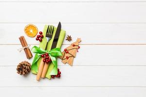 Top view of utensils on festive napkin on wooden background. Christmas decorations with dried fruits and cinnamon. New year dinner concept with copy space photo