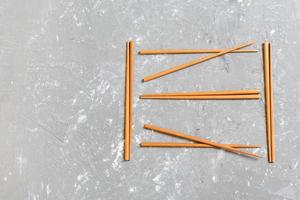 Many bamboo chopsticks on black cement stone background, top view with copy space. a lot of sushi sticks in the form of an ornament photo