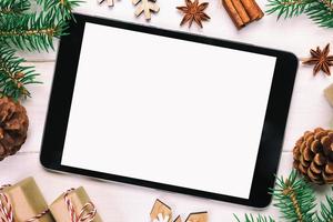 Digital tablet mock up with rustic Christmas wooden background decorations for app presentation. top view vintage, toned with copy space photo