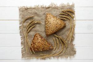 Golden fresh handicraft bread or buns with wheat ear on white table photo