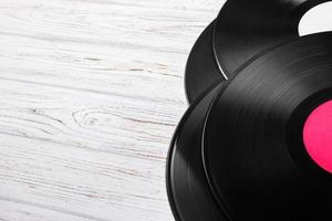 Top view of vinyl records stack over light wooden table with copy space for text photo