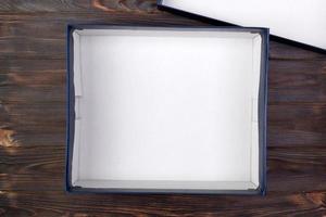 Open Cardboard white box on a dark table, wooden background. top view photo