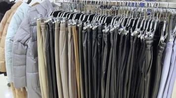 roupas penduradas em cabides na loja, escolha de cores e modelos diferentes. video