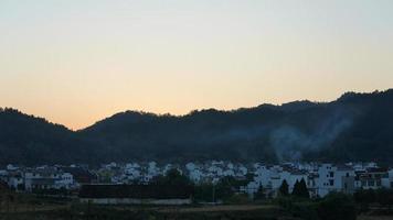 The beautiful traditional Chinese village view with the classical architecture and fresh green trees as background photo