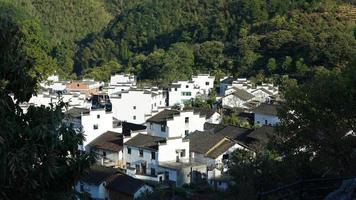 The beautiful traditional Chinese village view with the classical architecture and fresh green trees as background photo