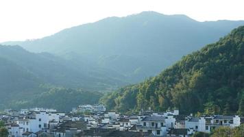 la hermosa vista del pueblo chino tradicional con la arquitectura clásica y árboles verdes frescos como fondo foto