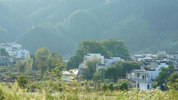 The beautiful traditional Chinese village view with the classical architecture and fresh green trees as background photo
