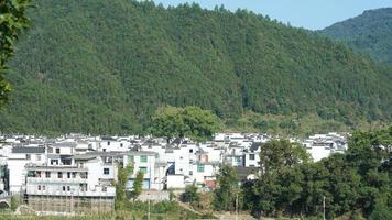 The beautiful traditional Chinese village view with the classical architecture and fresh green trees as background photo