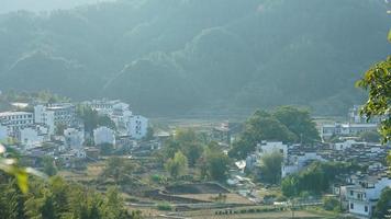 The beautiful traditional Chinese village view with the classical architecture and fresh green trees as background photo