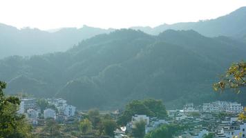 The beautiful traditional Chinese village view with the classical architecture and fresh green trees as background photo