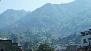 The beautiful traditional Chinese village view with the classical architecture and fresh green trees as background photo