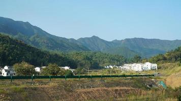 The beautiful traditional Chinese village view with the classical architecture and fresh green trees as background photo