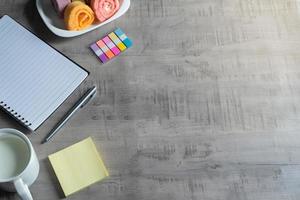 cuaderno, teléfono inteligente, rollo de mermelada, taza de leche, bolígrafo en madera, negocio de notas de papel, concepto y diseño de educación foto