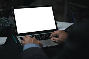 Business man using laptop computer looking with blank screen for mock up template background, business technology. photo