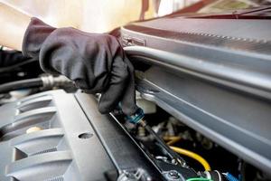 Technician is using a screwdriver lock bolt of Injector rail Fuel pipe for repair car and maintenance concept photo