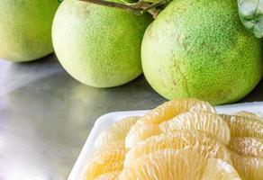 Close up many pomelo peeled and pomelo on the table A fruit from Asia with a sweet and sour taste photo