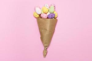 Easter colorful eggs in a paper bag on a pink background, Easter concept, Easter card, Easter bouquet photo