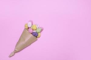 Easter colorful eggs in a paper bag on a pink background, Easter concept, Easter card, Easter bouquet photo