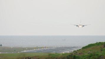 vue de la piste et des avions atterrissant sur le fond de l'océan. atterrissage d'un avion de ligne à phuket video