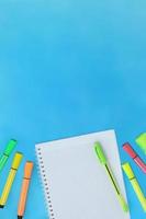 De vuelta a la escuela. concepto de educación marcadores cuaderno cuadriculado con bolígrafo para texto sobre fondo azul con espacio en blanco foto