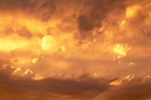 Sunset or dawn sky, yellow clouds with rays and hidden sun. Heaven high Copy space photo