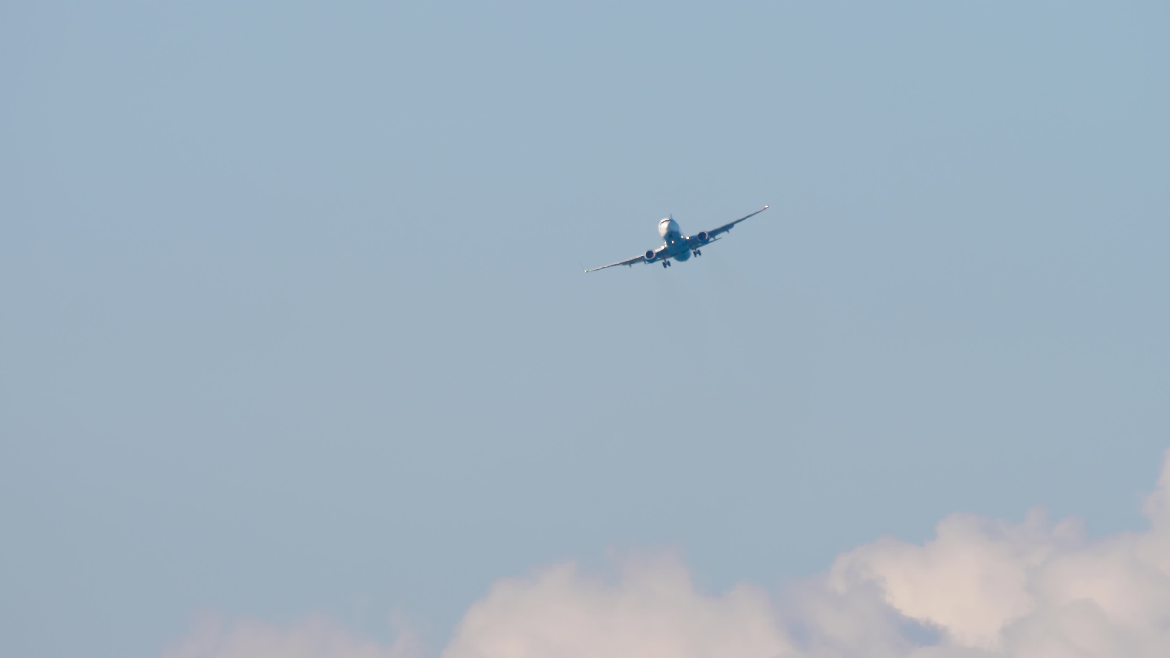 Unrecognizable passenger plane gaining altitude after takeoff. Airliner