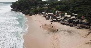 vue aérienne, jeunes jouant au football sur la plage de la plage de gunungkidul, indonésie. video