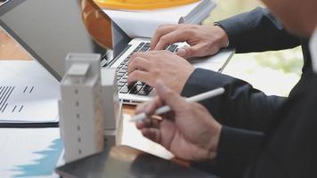 bespreking met een makelaar, huismodel met makelaar en klant bespreken voor het contract om onroerend goed of onroerend goed te kopen, een verzekering of lening af te sluiten. video