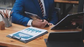 homme d'affaires travaillant avec un téléphone intelligent et un ordinateur portable et une tablette numérique au bureau avec des supports de marketing numérique dans une icône virtuelle video